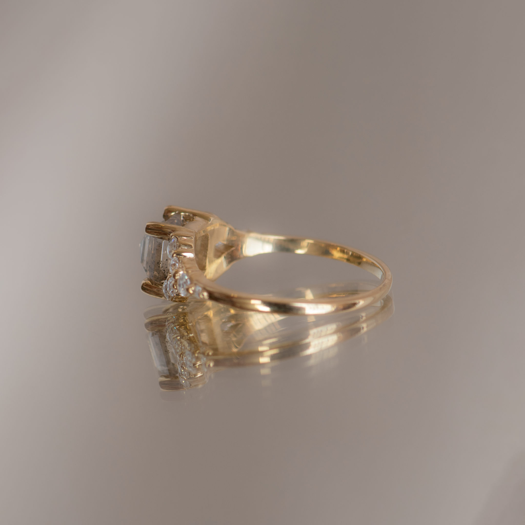 Emerald cut salt and pepper diamond engagement ring with split band, made with rose cut diamonds in 14k yellow gold.