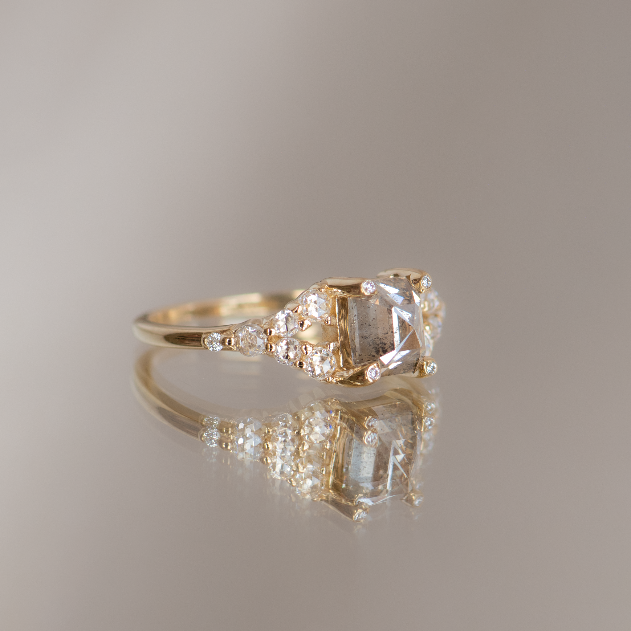 Emerald cut salt and pepper diamond engagement ring with split band, made with rose cut diamonds in 14k yellow gold.