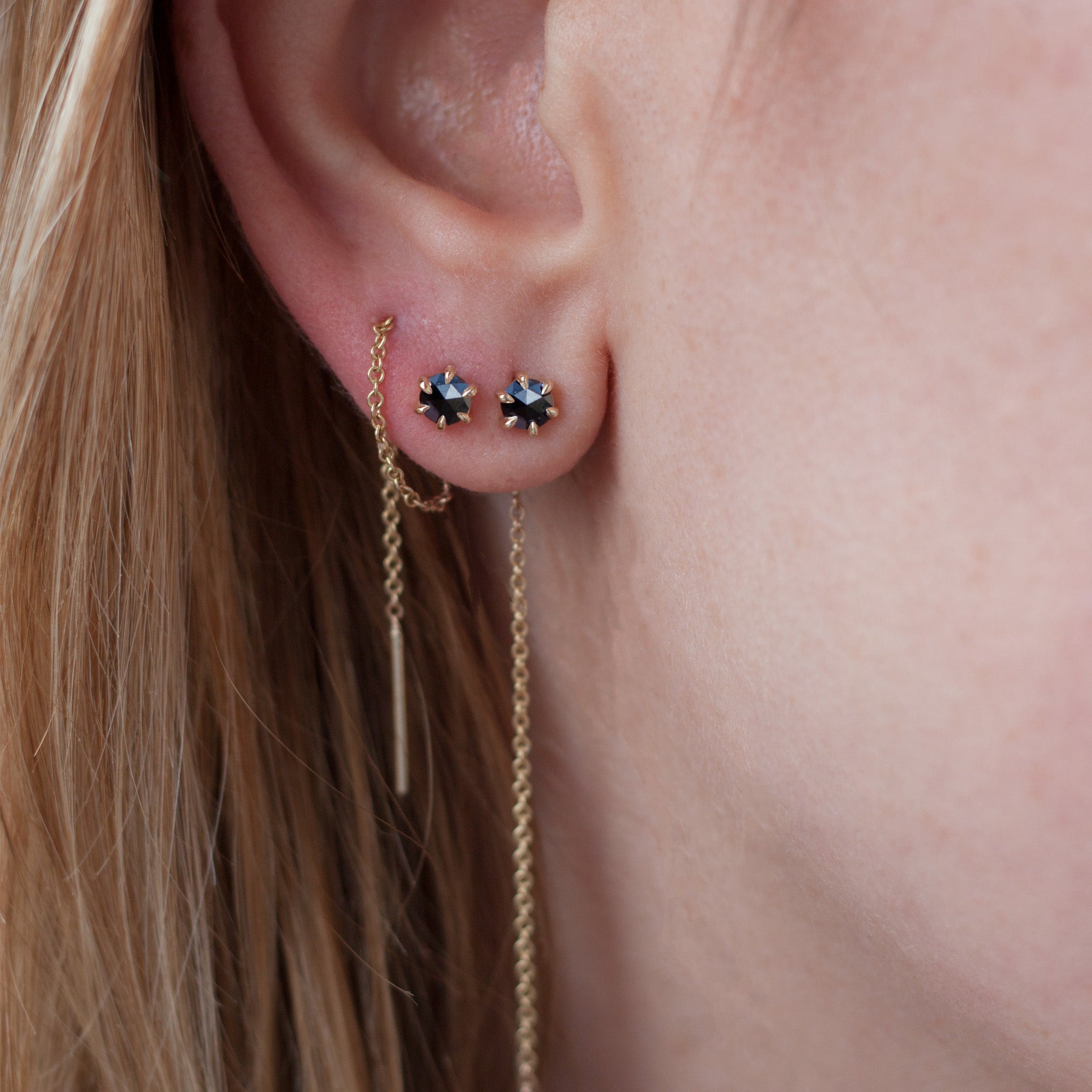 Delicate black round rose cut diamond threaders, ideal for threading through multiple piercings, feature a six claw prong setting, using 14k or 18k yellow gold.